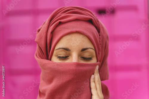 Horizontal portrait of muslim woman wearing hiyab with eyes closed. Cultural diversity and religion. photo