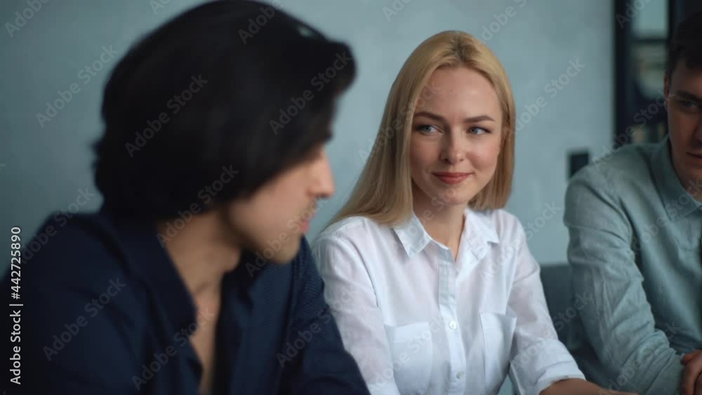 Close-up of creative business team of three people discussing business plan while sitting at table in modern office room. Startup team of young businesspeople working on business project with laptop. Close-up of creative business team of three people discussing business plan while sitting at table in modern office room. Startup team of young businesspeople working on business project with laptop.