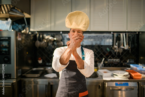 Φωτογραφία Male chef tossing pizza dough in the air