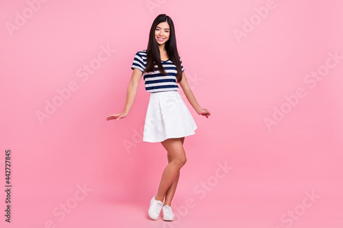 Full length body size photo of young woman in stylish outfit smiling isolated pastel pink color background