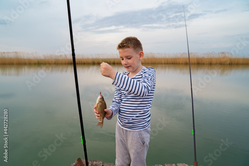A boy catches a fish on fishing rod. men's hobby.