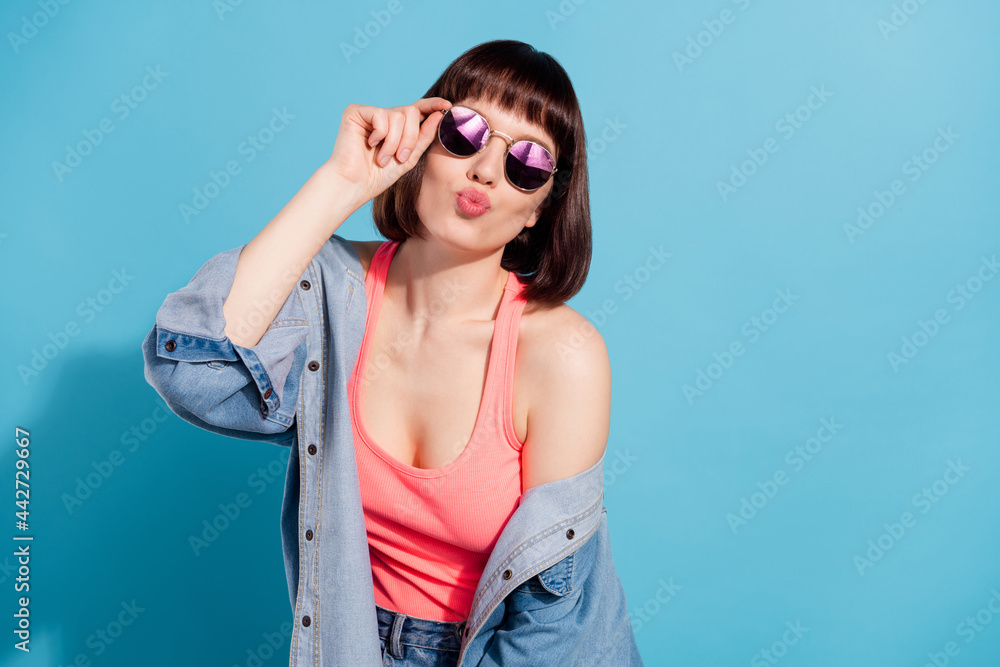 Portrait of attractive girl sending you air kiss posing touching specs good mood isolated over bright blue color background Portrait of attractive girl sending you air kiss posing touching specs good mood isolated over bright blue color background