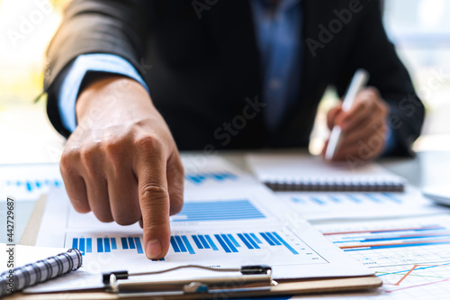 Business man investment consultant analyzing company annual financial report balance sheet statement working with documents graphs. Concept picture of business, market, office, tax.
