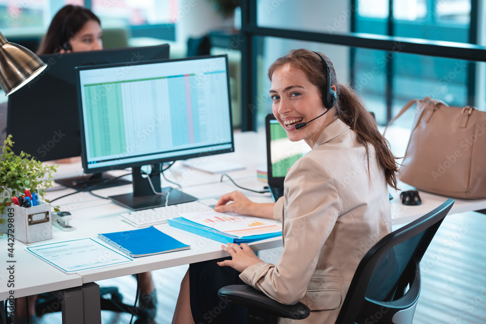 Portrait of caucasian businesswoman wearing headset and sitting at table smiling Portrait of caucasian businesswoman wearing headset and sitting at table smiling