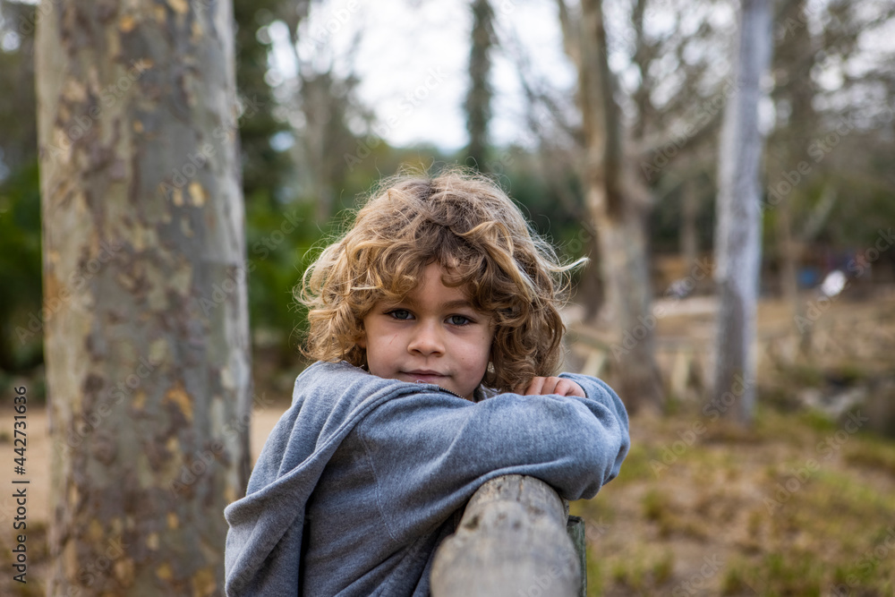 Boy leaning on fence against pond in the park Boy leaning on fence against pond in the park