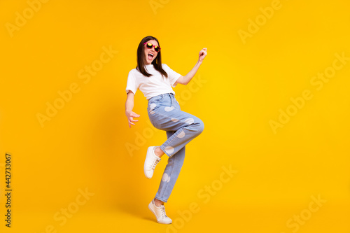 Full body profile side photo of young excited girl happy positive smile play guitar isolated over yellow color background