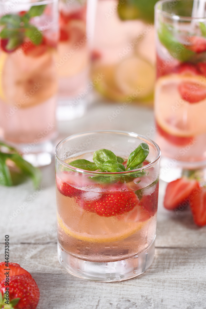Summer strawberry cocktail or lemonade with basil. Cold refreshing organic soft drink with ripe berries in a glass Summer strawberry cocktail or lemonade with basil. Cold refreshing organic soft drink with ripe berries in a glass