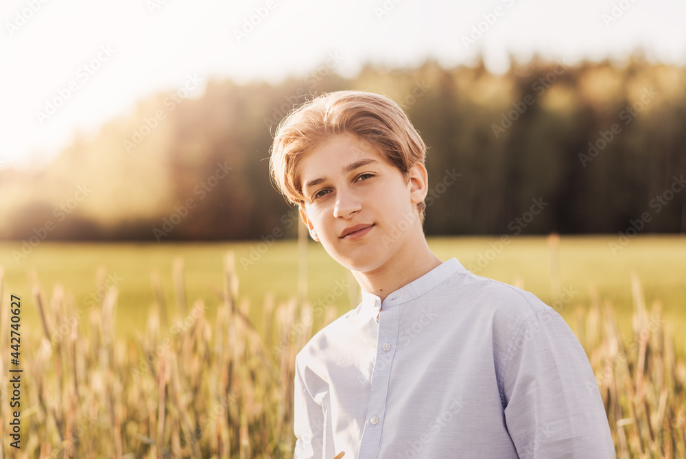 Portrait of a beautiful of millennial boy in nature in the summer. A look at the camera Portrait of a beautiful of millennial boy in nature in the summer. A look at the camera