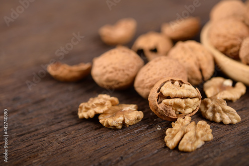 whole and peeled dried walnuts on wooden backbground photo