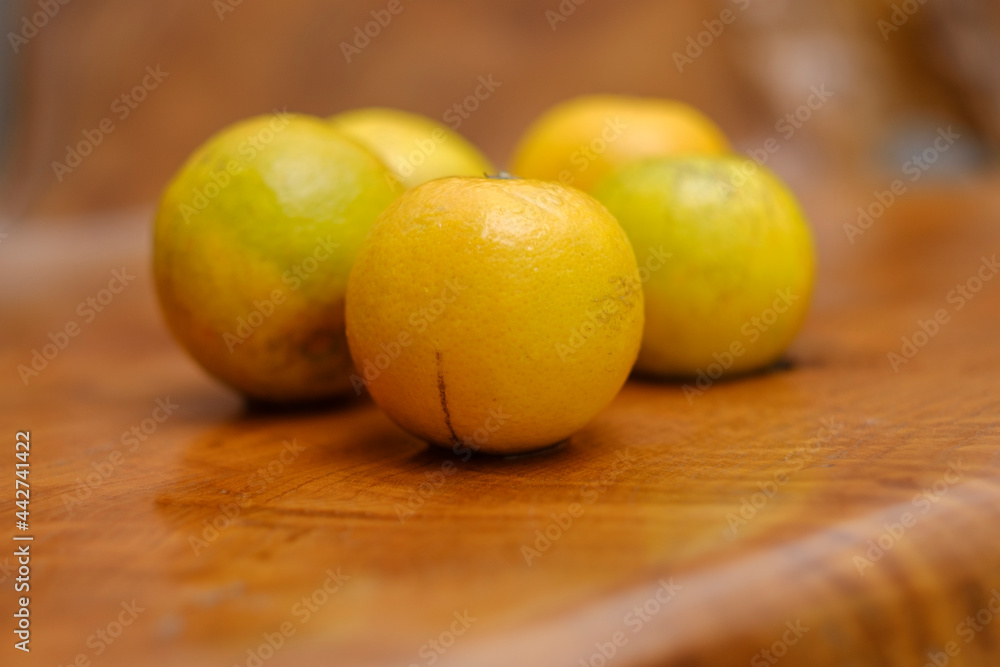 Baby oranges on edge of wooden table. All things yellow. Baby oranges on edge of wooden table. All things yellow.