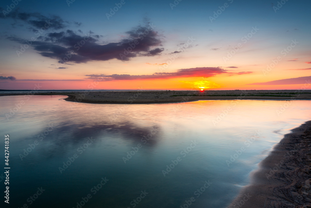 Obraz premium A beautiful sunset on the beach of the Sobieszewo Island at the Baltic Sea. Poland