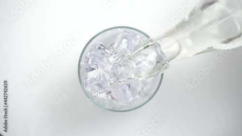 Vertiendo agua en un vaso con hielos, vista desde arriba photo