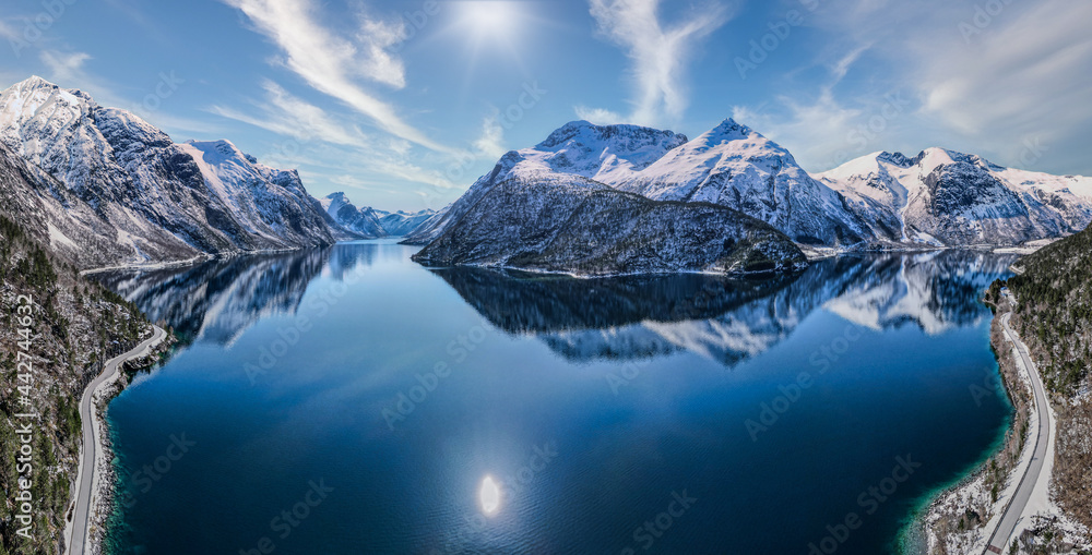 Wide shot of reflecting water with snowy peaks
