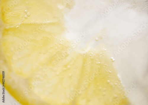 Bubbles from a slice of lemon in lemonade with ice v2.