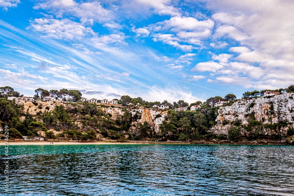 beautiful beach in menorca with blue sky and white clouds