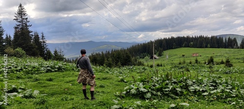 A man stands near the mountains