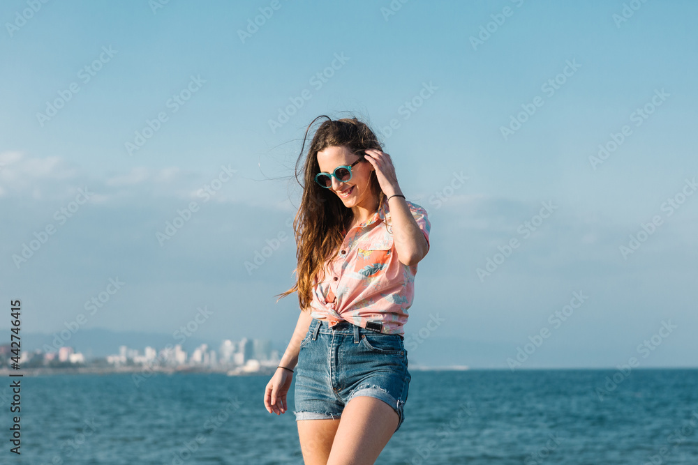 Trendy young woman in summer outfit and sunglasses Trendy young woman in summer outfit and sunglasses