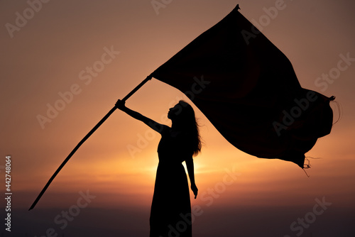 旗を持つ女性のシルエット