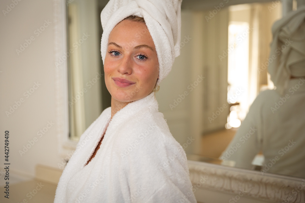 Portrait of smiling caucasian woman in bathroom with towel on head Portrait of smiling caucasian woman in bathroom with towel on head