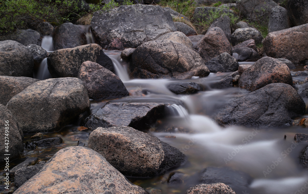 mountain waterfall on the background of round stones mountain waterfall on the background of round stones