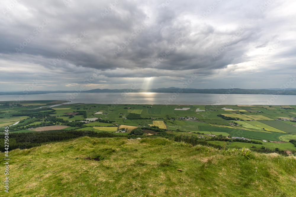 Beautiful mountain landscape with sea, clouds and sun in Binevenagh North Ireland
