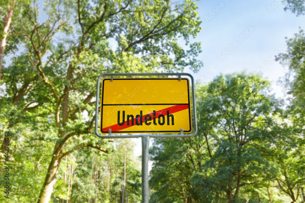 Unusual yellow german town sign indicating the city limits of Undeloh leading to nowhere or straight into wilderness...