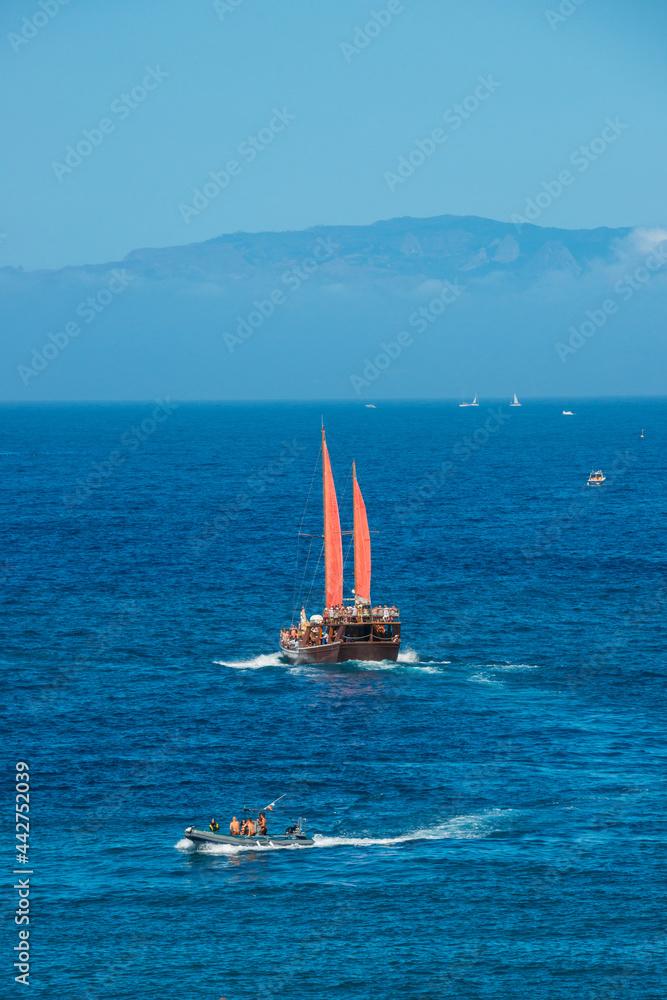 Naklejka premium Paisaje con barcos de recreo navegando en la costa sur de Tenerife con vista de la isla de Gomera en el horizonte