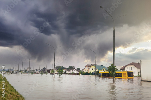 Extreme heavy rain storm weather. Flooded streets of the neighborhood. A flooded road junction with a drowned house. Heavy rains from tropical storm caused many flooded areas. Rains caused many floods photo