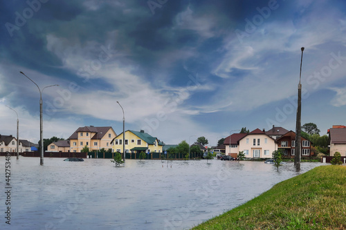 Extreme heavy rain storm weather. Flooded streets of the neighborhood. A flooded road junction with a drowned house. Heavy rains from tropical storm caused many flooded areas. Rains caused many floods