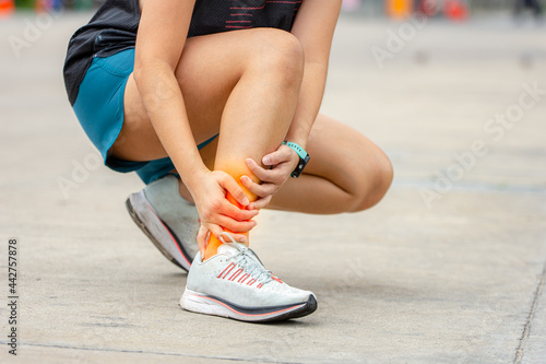 Sport woman has sore ankle from exercising training. It is a common injury for runner. Ankle pain, painful point.