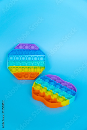 colorful silicon antistress sensory toy fidget push pop it on blue background