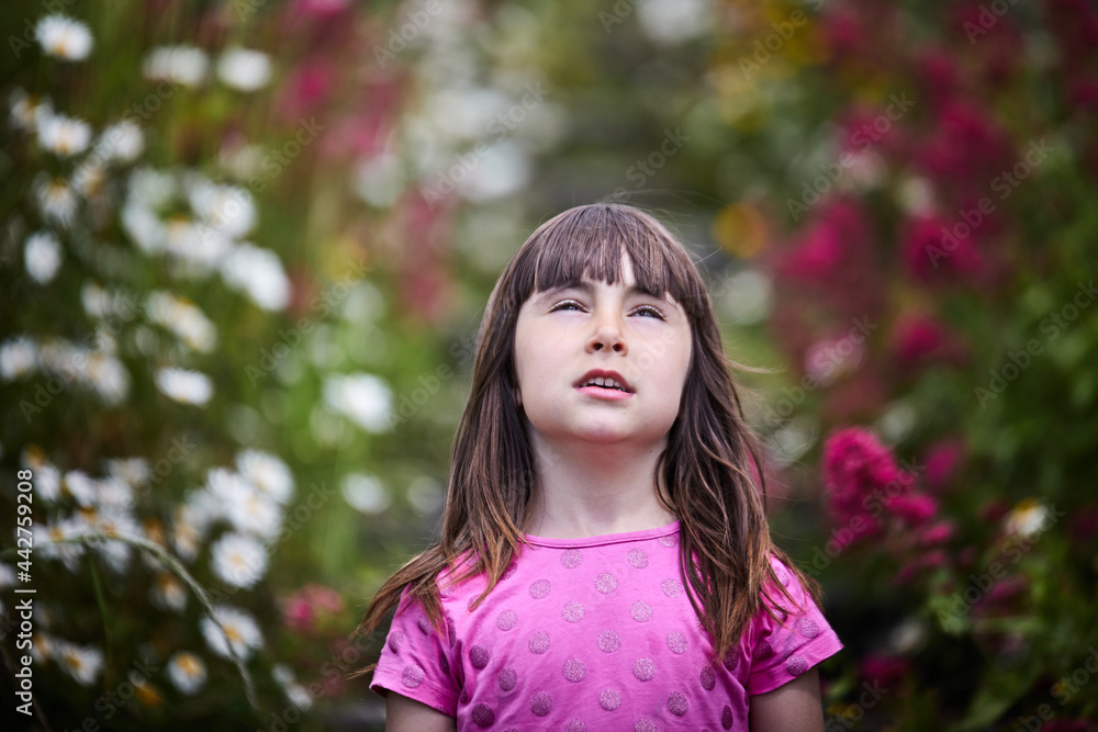 Caucasian girl with unfocused background surrounded by many flowers. summer and spring image. Caucasian girl with unfocused background surrounded by many flowers. summer and spring image.