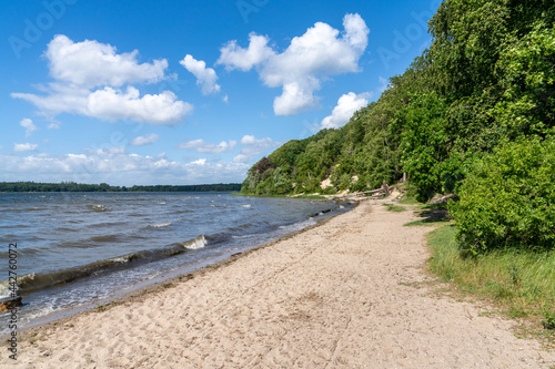 view of the Roskilde Fjord with a sandy beach and forest on the shoreline