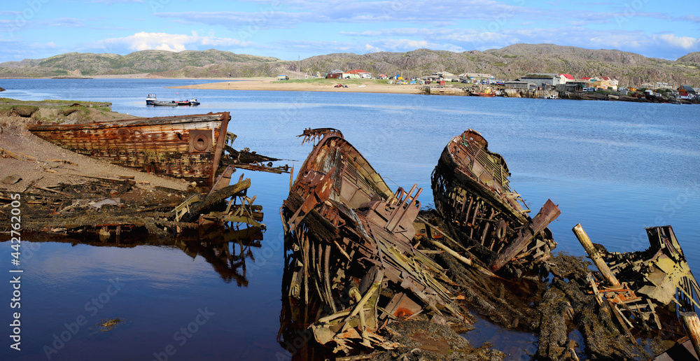 rusty skeletons of submerged schooners on the picturesque seashore. Kola peninsula Teriberka