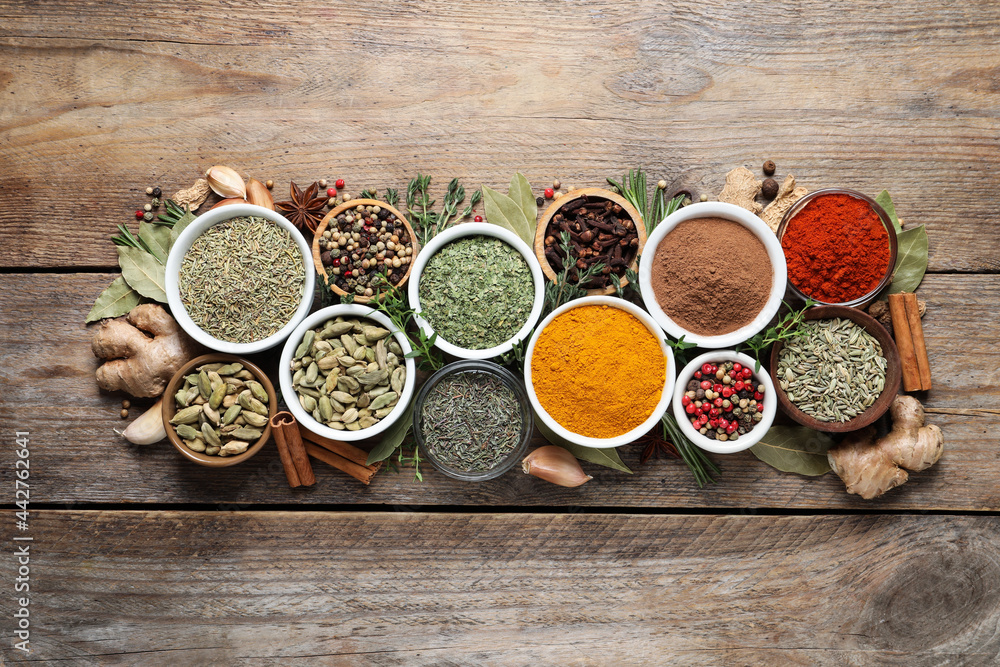 Flat lay composition with different natural spices and herbs on wooden table Flat lay composition with different natural spices and herbs on wooden table