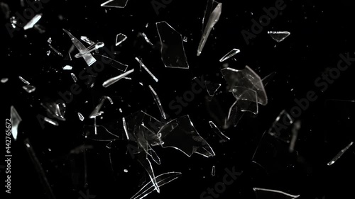 Super Slow Motion studio full-frame wide plate shot of window glass pane shattering and breaking on black background. Real smash explosion at high speed as action concept template and overlay element.
