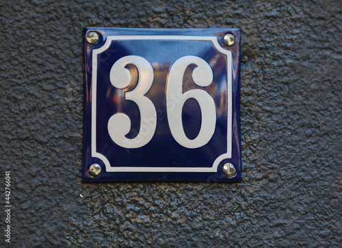 Vintage grunge square metal rusty plate of number of street address with number. Close up, brand.