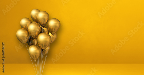 Gold balloons bunch on a yellow wall background. Horizontal banner.