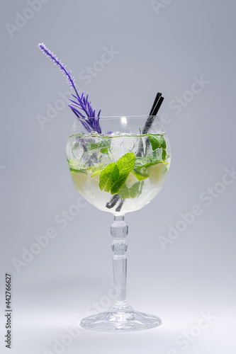 cocktail hugo or mojito with mint, lime and ice in wineglass on white background