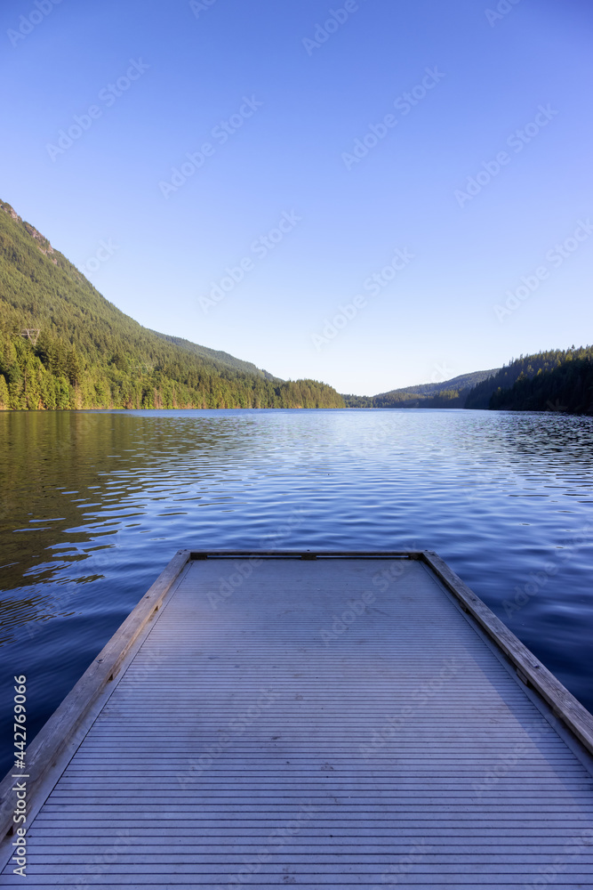 View of Buntzen Lake surrounded by Canadian Mountain Landscape. Sunny Summer Evening. Located in Anmore, Vancouver, British Columbia, Canada. Nature Background View of Buntzen Lake surrounded by Canadian Mountain Landscape. Sunny Summer Evening. Located in Anmore, Vancouver, British Columbia, Canada. Nature Background