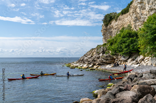 Fototapeta Naklejka Na Ścianę i Meble -  group of sea kayakers make a landing on a rocky beach on the coast of Denmark at Stevns Klint