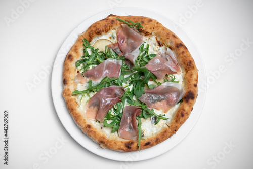 top view of tasty pizza with prosciutto, arugula and cheese on white background