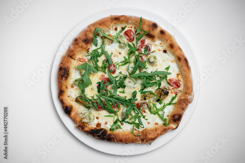top view of seafood pizza with shrimp, mussels and arugula on white background