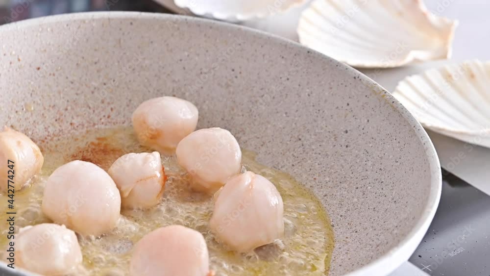 Chef preparing healthy gourmet food, seared scallops in a frying pan. A traditional dish of france and italy sea food. Chef preparing healthy gourmet food, seared scallops in a frying pan. A traditional dish of france and italy sea food.