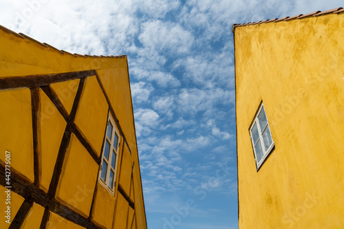 half-timbered yellow houses in stark contrast under a blue sky with cumulus clouds photo