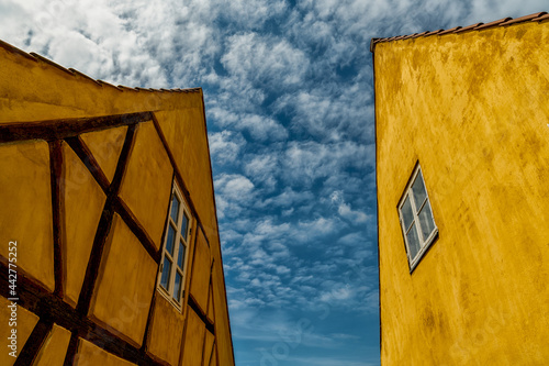 half-timbered yellow houses in stark contrast under a blue sky with cumulus clouds photo