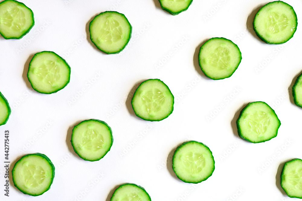 repeating pattern of sliced semicircles of fresh raw vegetable cucumbers for salad isolated on a white background flat lay, top view repeating pattern of sliced semicircles of fresh raw vegetable cucumbers for salad isolated on a white background flat lay, top view