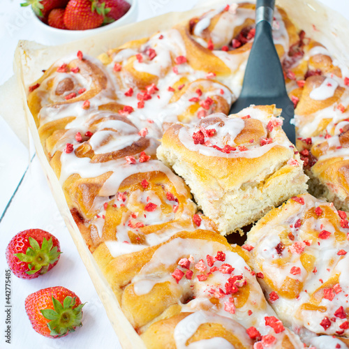 Vanilla yeast rolls with strawberries and frosting. Homemade yeast buns.