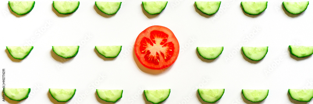 repeating pattern of sliced semicircles of fresh raw vegetable cucumbers for salad and a slice of tomato in the center isolated on a white background flat lay, top view. banner repeating pattern of sliced semicircles of fresh raw vegetable cucumbers for salad and a slice of tomato in the center isolated on a white background flat lay, top view. banner
