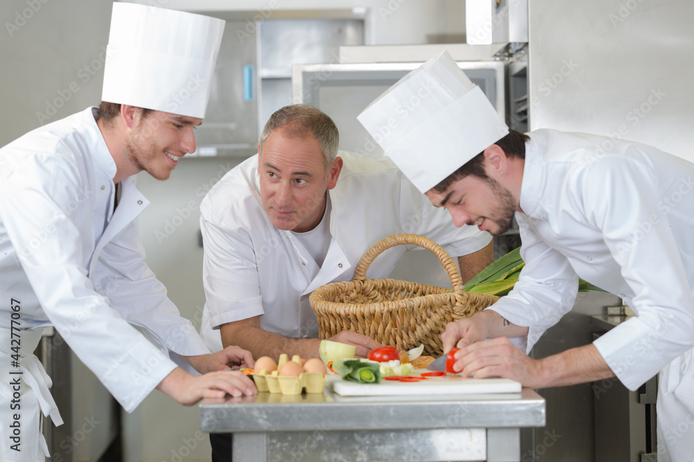 chefs preparing food in the kitchen of a restaurant chefs preparing food in the kitchen of a restaurant